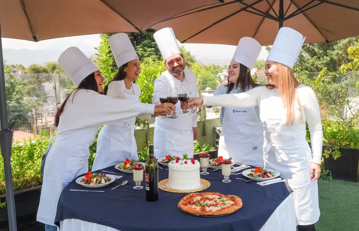 Un grupo con gorros de cocina comparte preparaciones al aire libre.