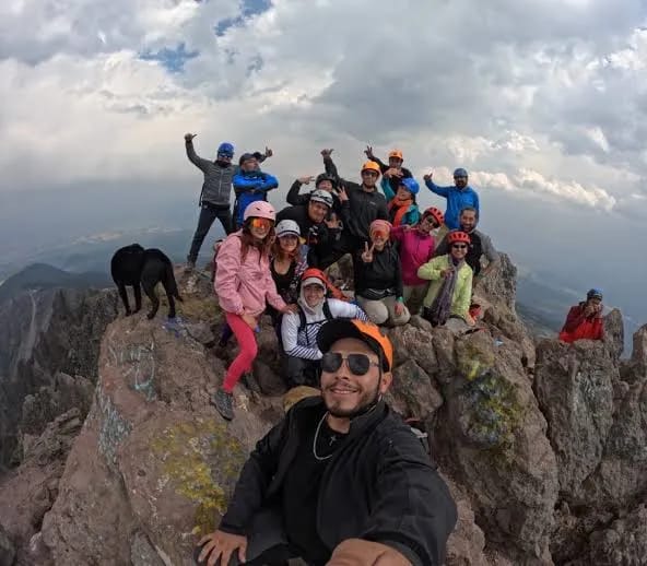 Un grupo se reúne en una cumbre rocosa.