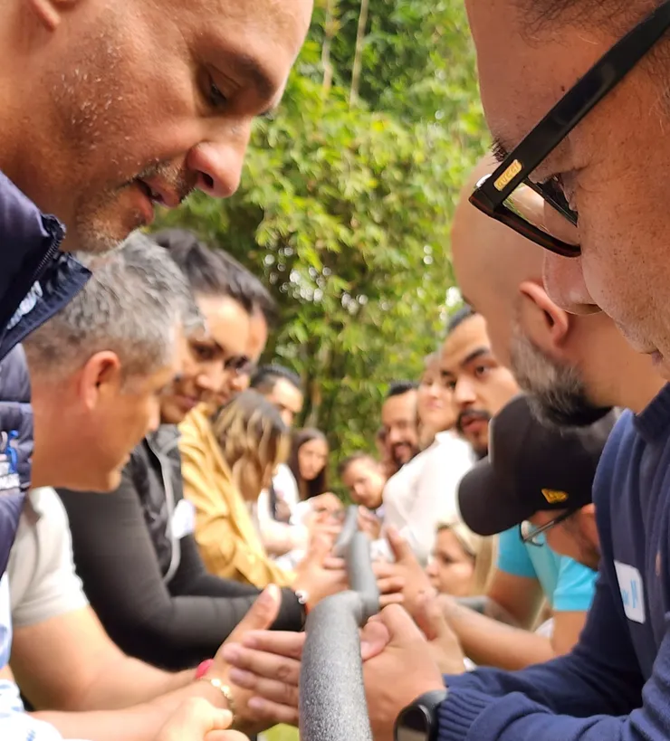 Participantes colaboran alineando piezas de un canal durante una dinámica.